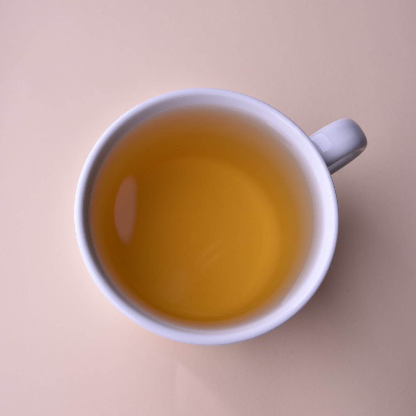 White mug filled with golden chenpi orange peel tea.