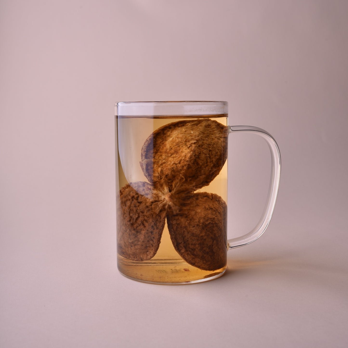 Clear tea glass with an aged orange peel steeping.