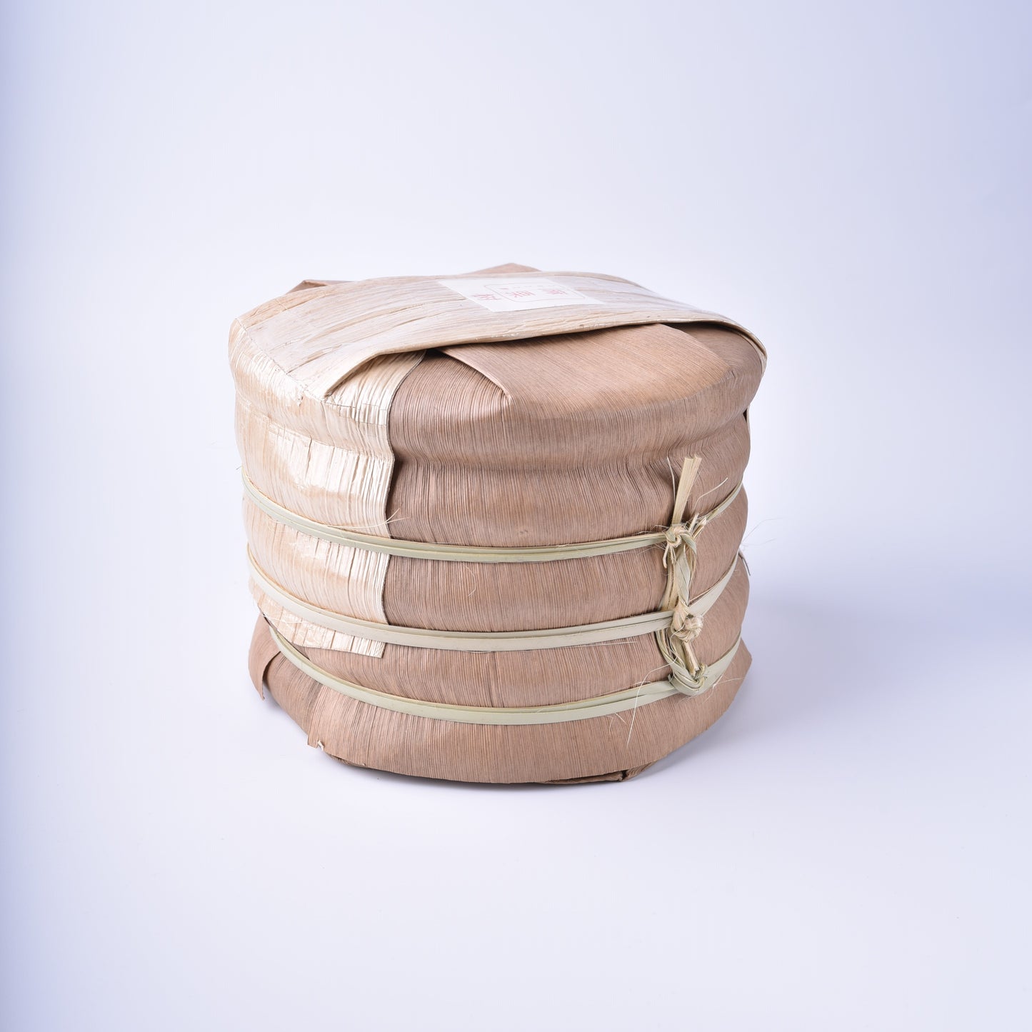 A tong of Ma Li Shu (Yibang) Gushu Spring 2022 Sheng / raw Puerh cake, bamboo wrapped.